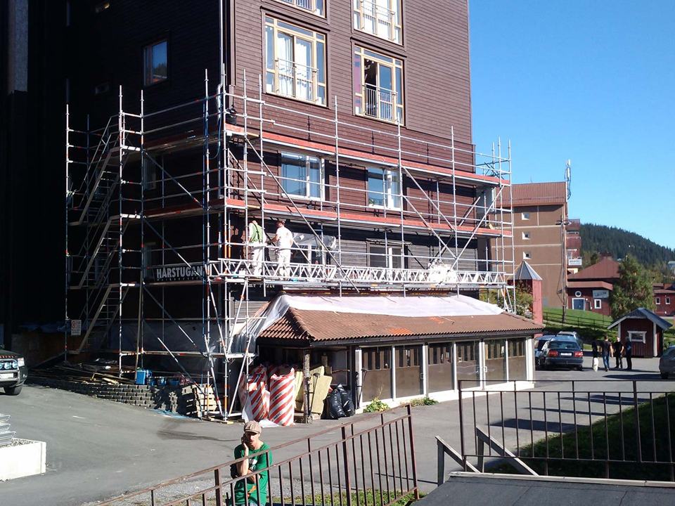 Högt flerbostadshus med fasadställning och trappa vid entrén