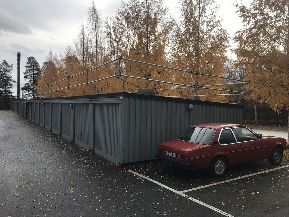 Skyddsräcke längs taket på en garagelänga