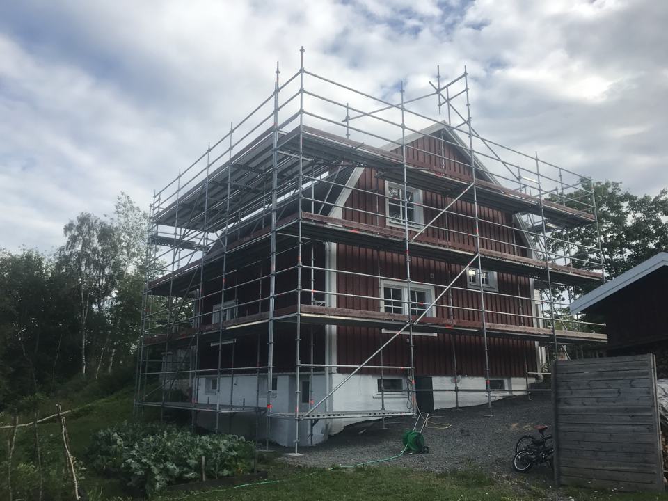 Rött trähus inbyggt i ställning en sommarkväll